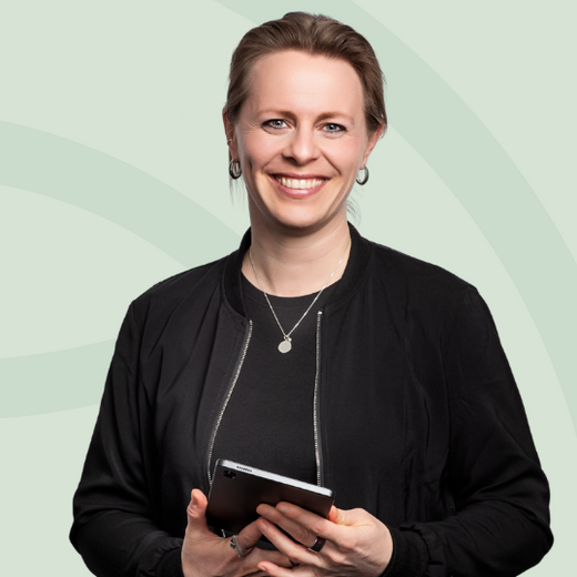 Eine lächelnde Frau hält ein Tablet in der Hand und steht vor einem hellgrünen Hintergrund. Neben ihr sind drei Abzeichen mit dem Wort "NETZWERK" abgebildet. Die Grafik vermittelt ein Gefühl von Professionalität und Innovation.