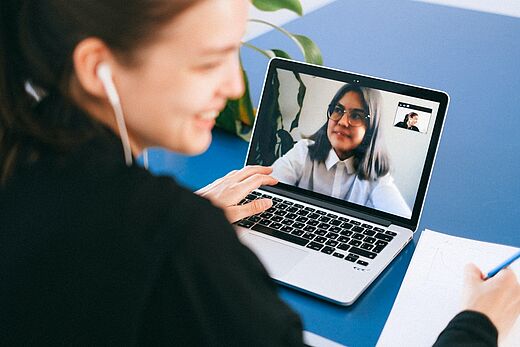 Zwei Frauen telefonieren online am Laptop